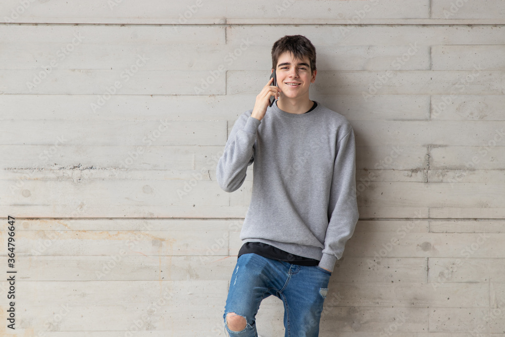 young male teenager with mobile phone on city street young male teenager with mobile phone on city street