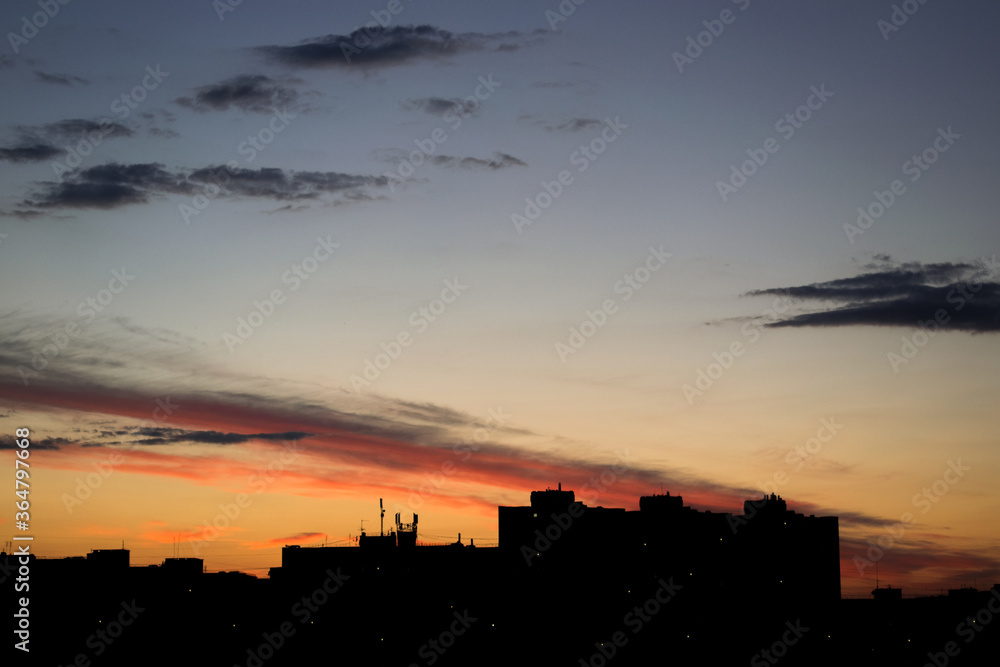 Sunset in the city. Silhouetted houses at sunset Sunset in the city. Silhouetted houses at sunset