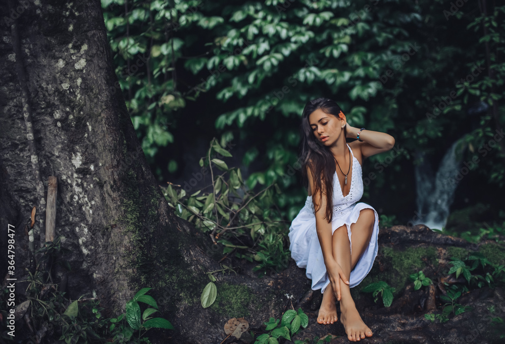 Girl walks in a white dress on a background of a waterfall. Girl walks in a white dress on a background of a waterfall.