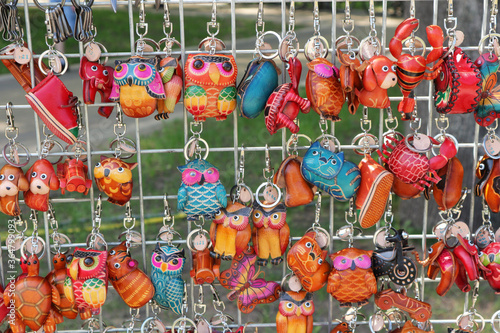 Leather keychains, handmade souvenirs hang on the lattice showcase for sale. photo