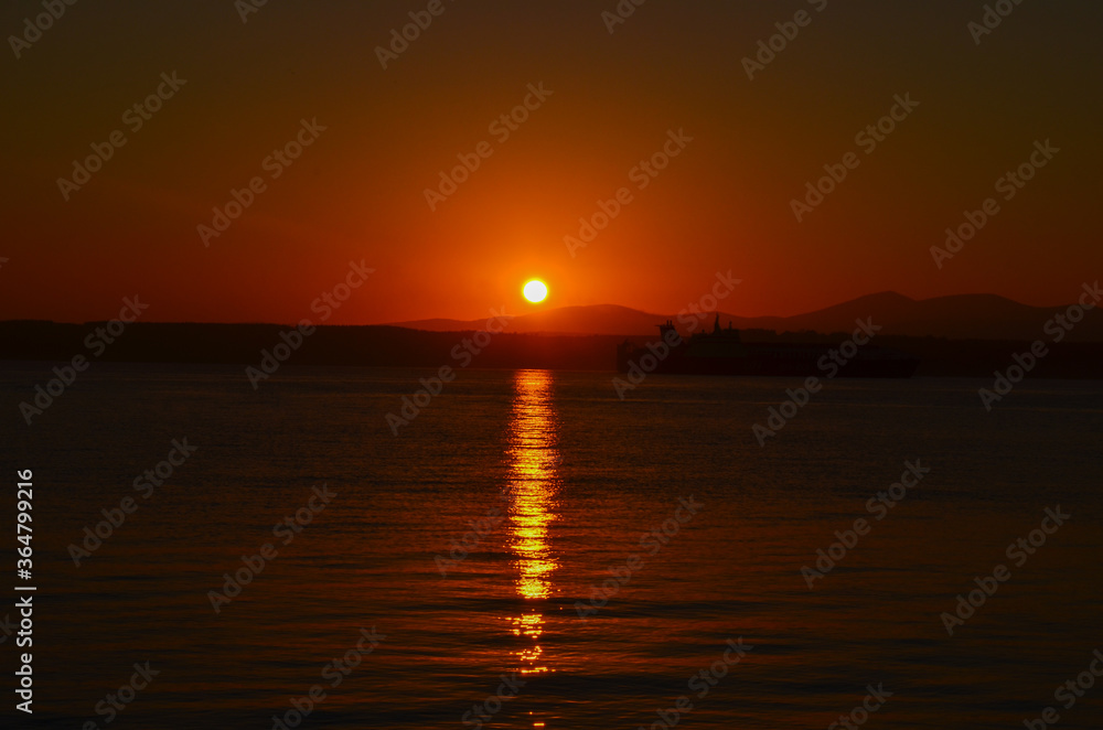 Canakkale with a sunrise and a steamer, morning hours, red colors, sunrise, orange, red, yellow colors
