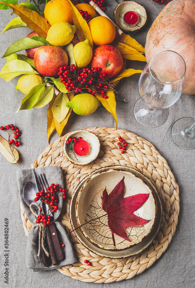 Autumn fall thankisgiving day table setting with pumpkins, fruits and yellow leaves, autumn decoration.