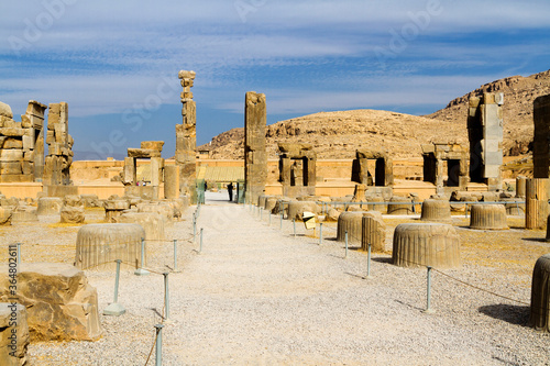 Ruins of Apadana and Tachara Palace behind stairway with bas relief carvings in Persepolis UNESCO World Heritage Site against cloudy blue sky in Shiraz city of Iran. Middle East, Asia photo