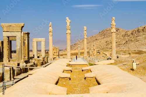 Ruins of Apadana and Tachara Palace behind stairway with bas relief carvings in Persepolis UNESCO World Heritage Site against cloudy blue sky in Shiraz city of Iran. Middle East, Asia photo