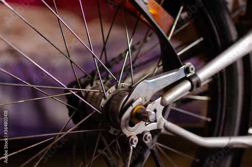 Close up of bicycle wheel and chain with purple background
