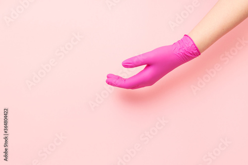 One hand in hygienic pink gloves. Place for text.