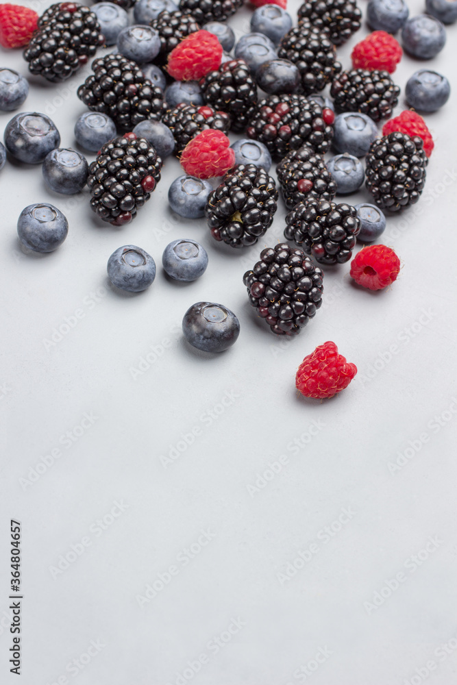 Blueberries, raspberries and blackberries on gray Blueberries, raspberries and blackberries on gray