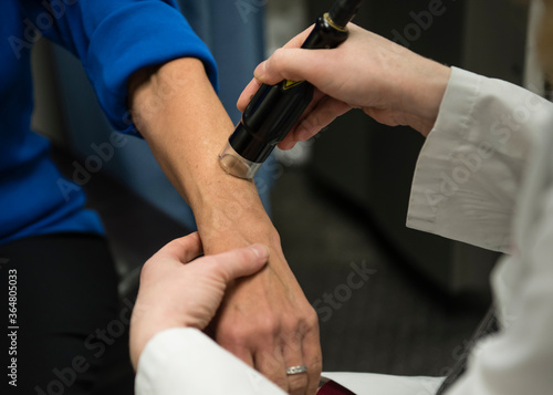 Dermatologist examining patient's skin