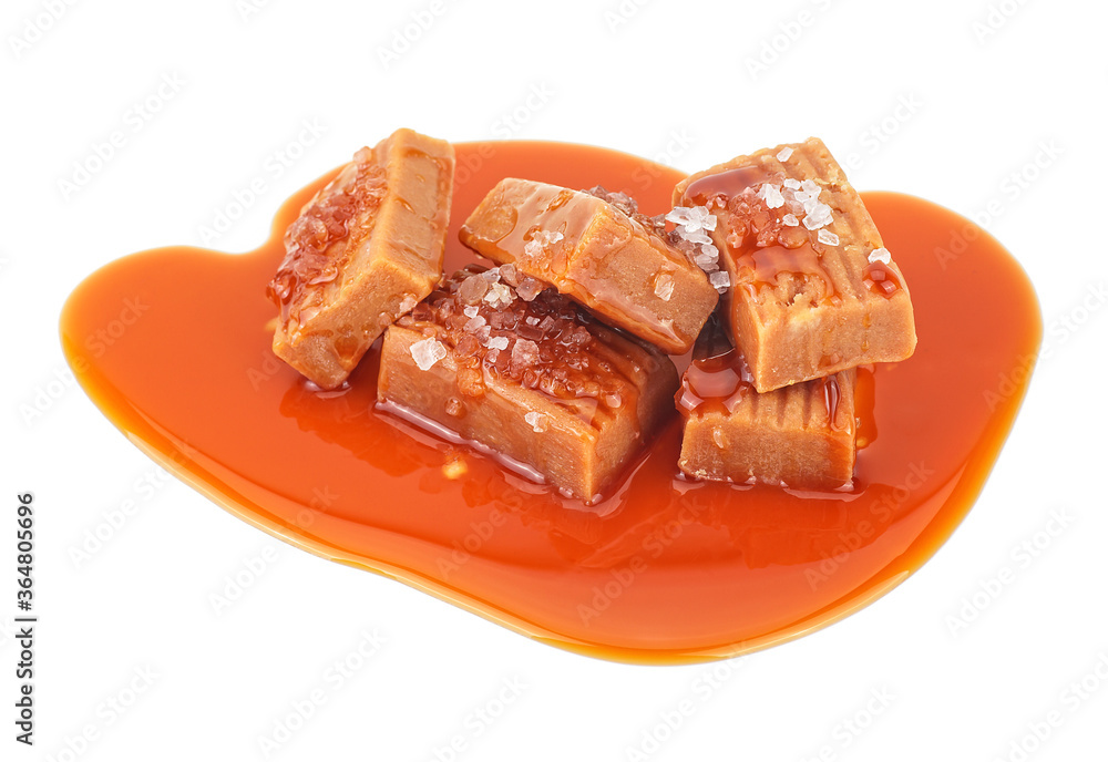 Delicious candies with caramel sauce and salt on a white background Delicious candies with caramel sauce and salt on a white background