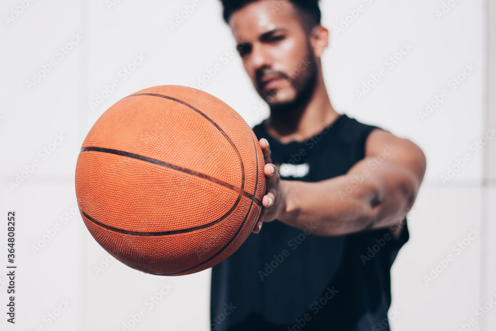 young man holds a basketball in front of the camera young man holds a basketball in front of the camera