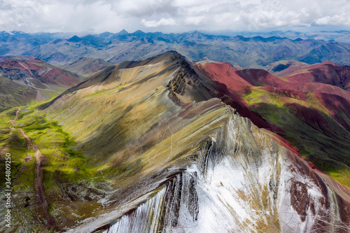 Rainbow mountain and snow-capped slope in Andes