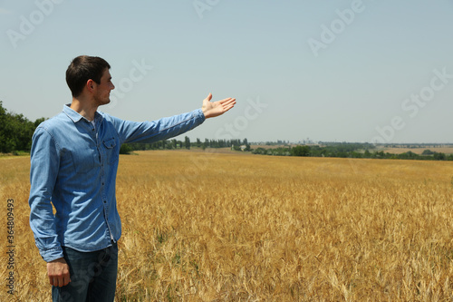 Young man in barley field. Agriculture business. Farming