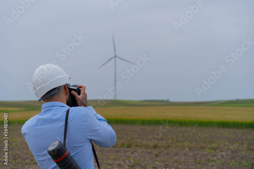 Engeneer taking picture of wind mill.