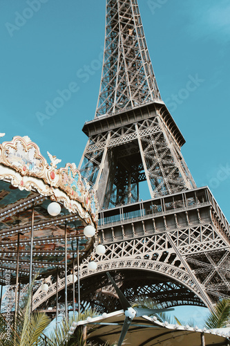 Retro colors Eiffel Tower with an old-fashioned nostalgic merry-go-round in Paris, France. 