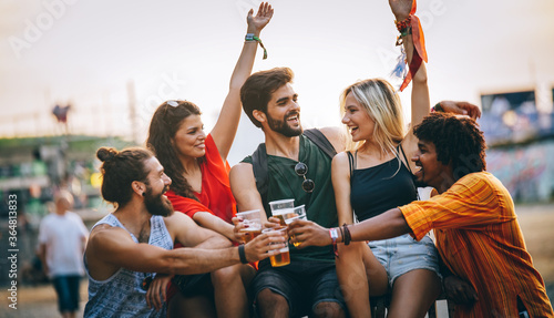 Group of happy friends drinking outdoors before festival