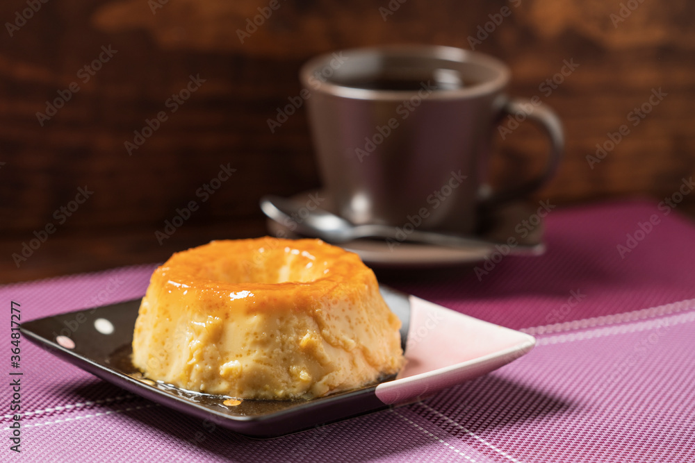 Delicious Caramel Flan on a square plate and a purple placemat. Wooden background Delicious Caramel Flan on a square plate and a purple placemat. Wooden background
