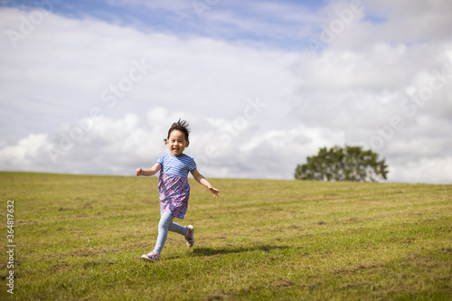 toddler girl running on summer countryside road