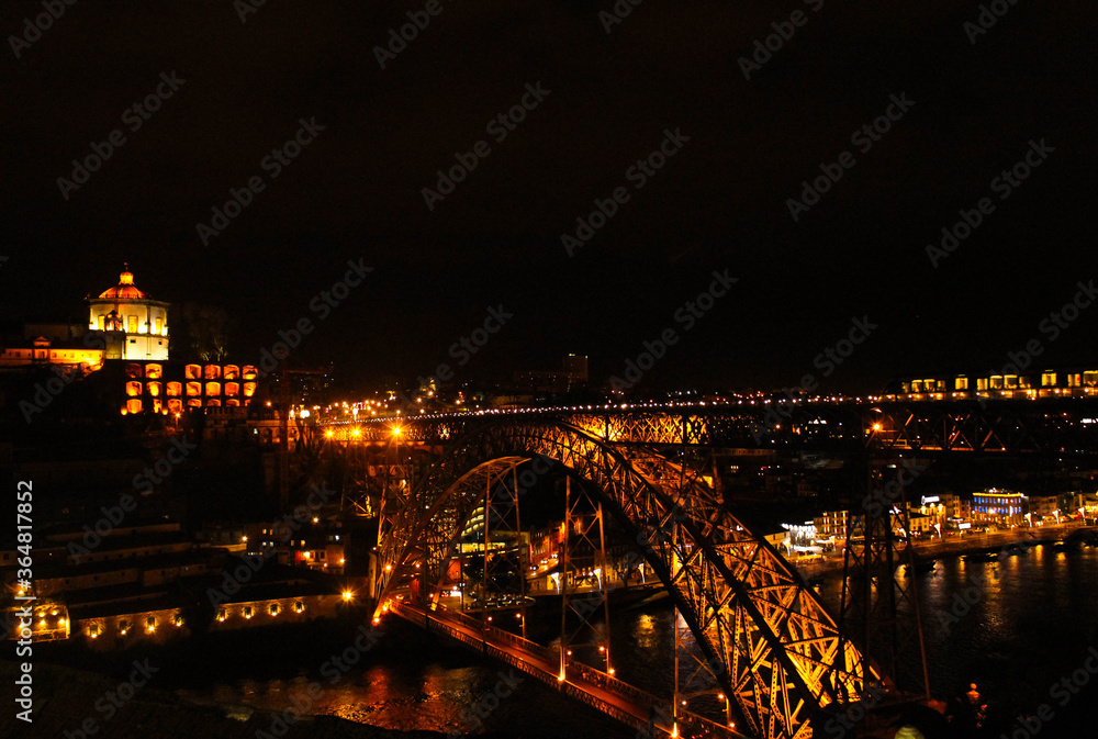 View of the D.Luis Bridge in Porto, lit up at night.