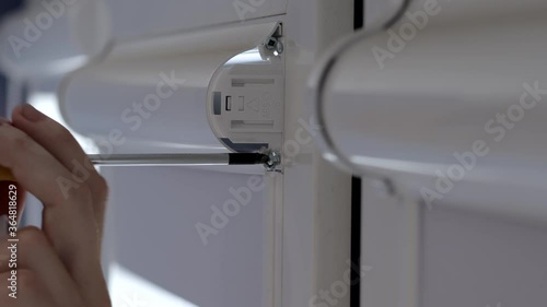 Man installing cassette roller blinds on windows