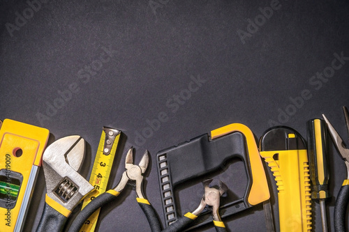 Tools for master builder prepared before work on black background with place for advertising