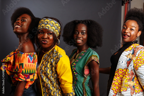 Four young beautiful African fashion models have fun and laughing in traditional dress. Women from the Congo Republic, Ivory Coast, and Zimbabwe