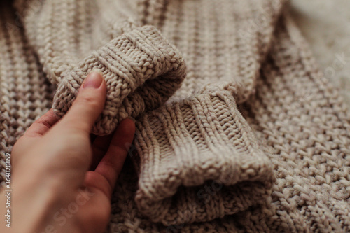 Female hand touches a warm and soft sweater.