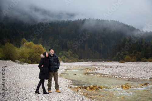 Couple standing next to the river photo