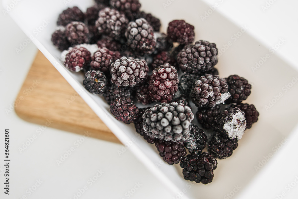 frozen blackberries in a lunch box on white background frozen blackberries in a lunch box on white background