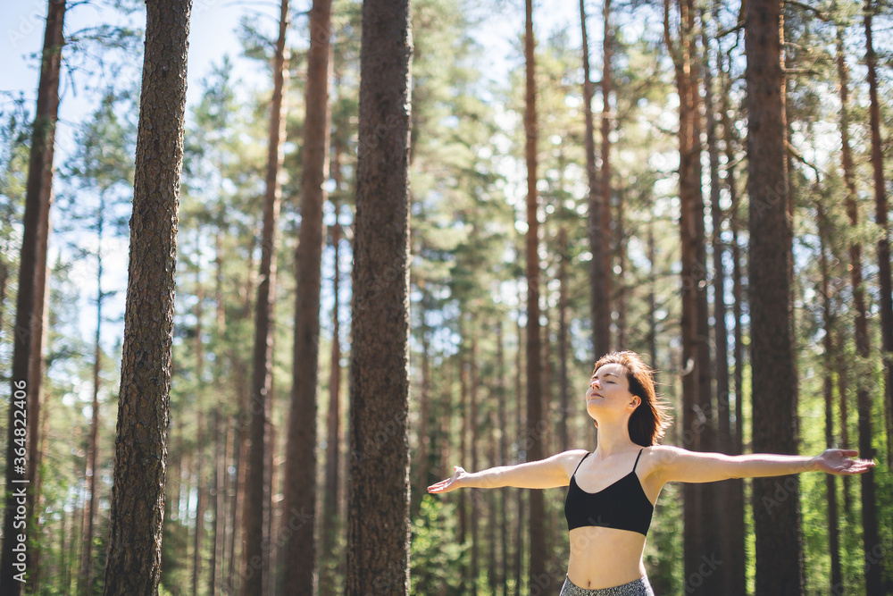 Happy woman with open hands against high trees and pine forest background. Person enjoy nature after yoga practicing. Freedom and imagination concept Happy woman with open hands against high trees and pine forest background. Person enjoy nature after yoga practicing. Freedom and imagination concept