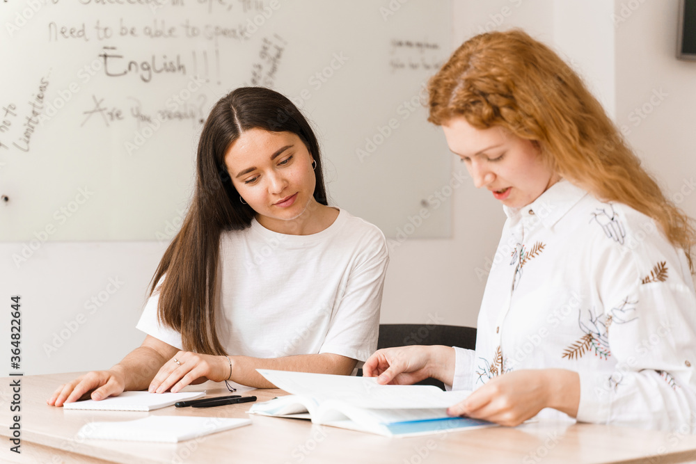 Teacher of english asks student in white class. 2 girls student answers to teacher. Working in group. Study english and british language. Teacher of english asks student in white class. 2 girls student answers to teacher. Working in group. Study english and british language.