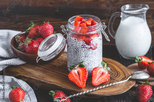 chia pudding with strawberry sauce, fresh berries and milk on rusic background photo