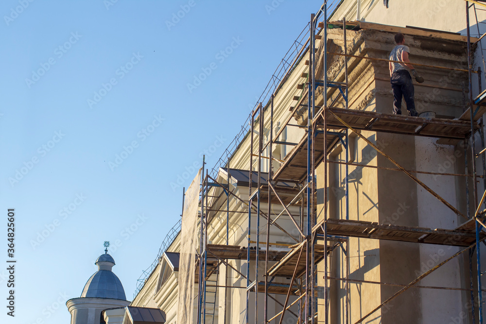 Worker on scaffolding at restoration work