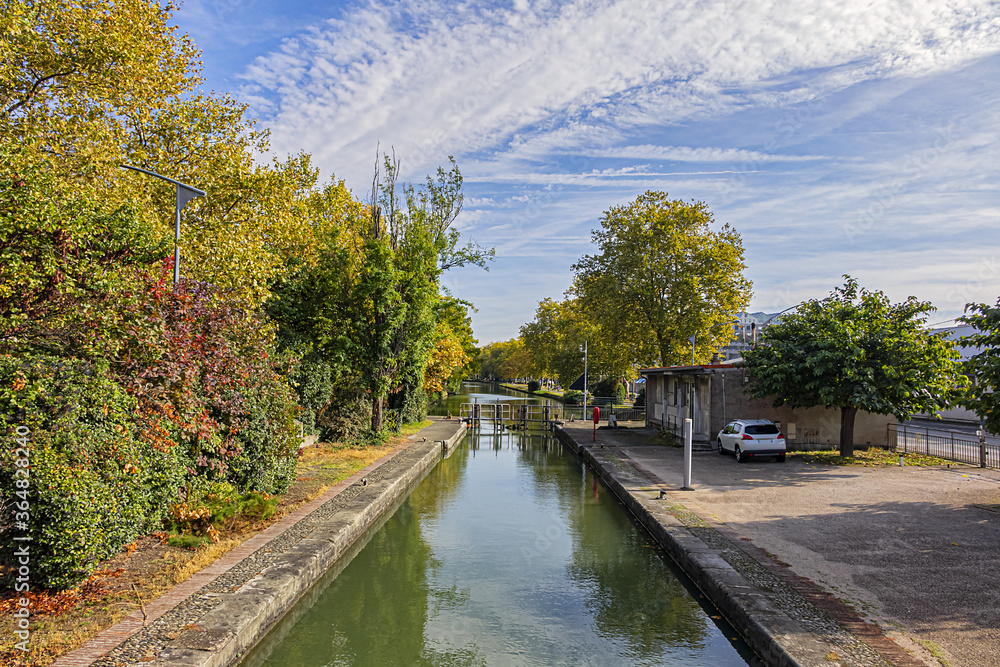 Beautiful autumn views of Canal du Midi (in XVII century - Royal Canal in Languedoc) in Toulouse and trees reflection in water. Toulouse, Haute-Garonne, France.