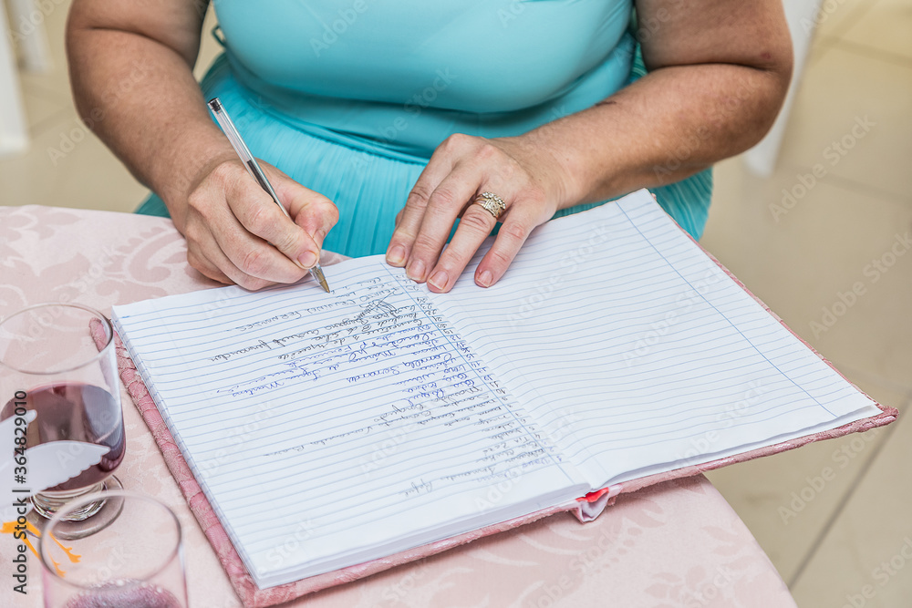 Naklejka premium Mulher usando caneta para escrever em caderno.