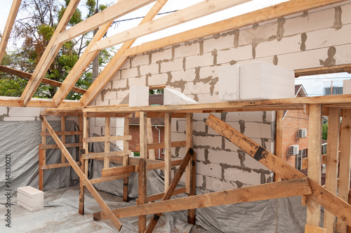 Tableau sur toile Building mansard roof on a house of the aircrete blocks