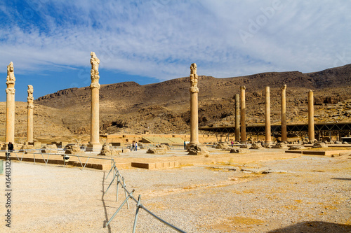 Ruins of Apadana and Tachara Palace behind stairway with bas relief carvings in Persepolis UNESCO World Heritage Site against cloudy blue sky in Shiraz city of Iran. Middle East, Asia photo