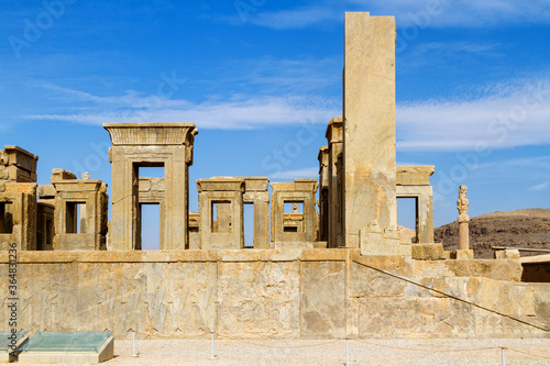 Ruins of Apadana and Tachara Palace behind stairway with bas relief carvings in Persepolis UNESCO World Heritage Site against cloudy blue sky in Shiraz city of Iran. Middle East, Asia photo