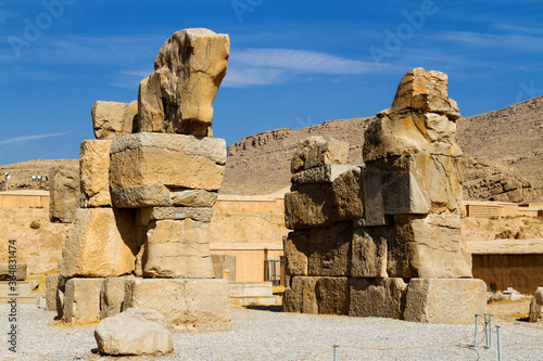 Ruins of Apadana and Tachara Palace behind stairway with bas relief carvings in Persepolis UNESCO World Heritage Site against cloudy blue sky in Shiraz city of Iran. Middle East, Asia photo