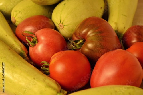 background of ripe tomatoes and green zucchini from their own beds