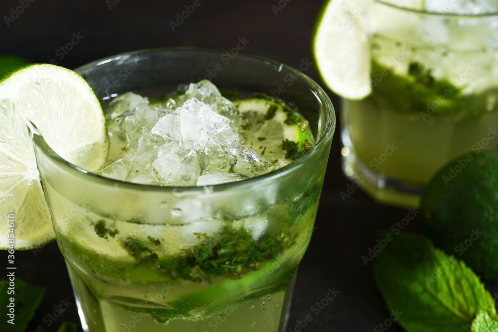 Summer cocktail. Classic summer drink - mojito in a glass on a dark background. Summer cocktail. Classic summer drink - mojito in a glass on a dark background.