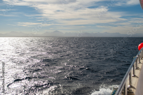 sea waves reflect sunlight. view from board of sightseeing yacht. clouds above horizon. © PavelNovakUA