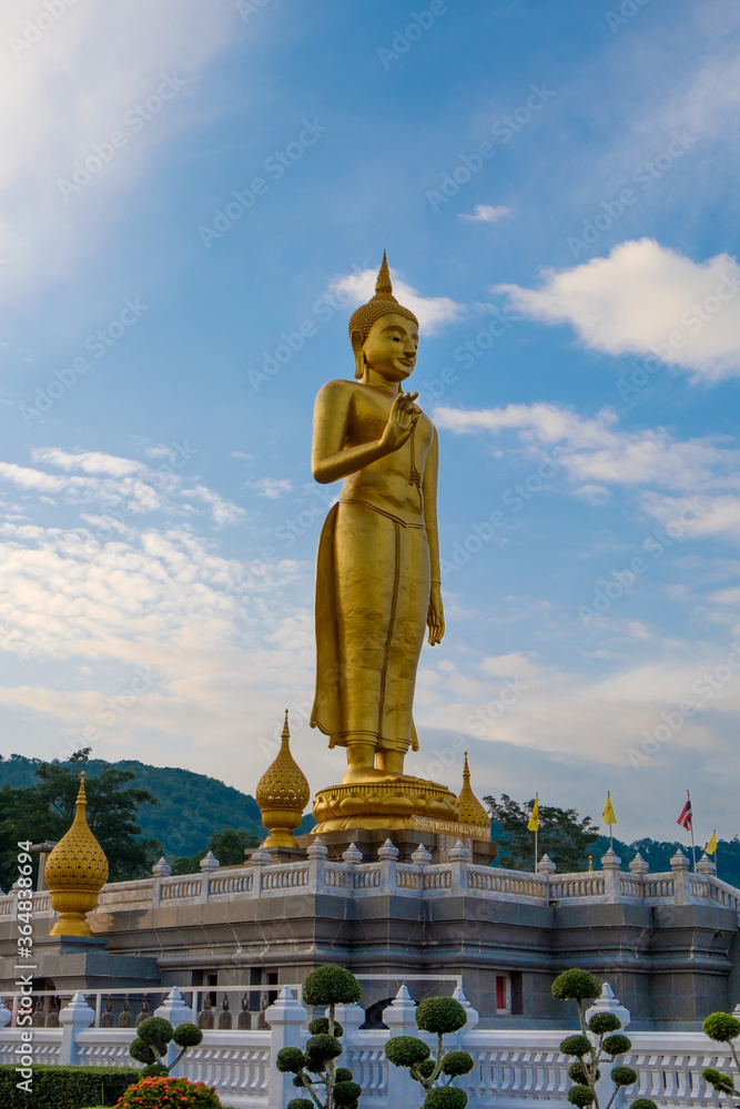 Fototapeta premium Hatyai, Thailand - June 29, 2016: Standing buddha and blue sky.