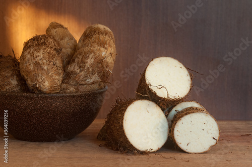 Fresh yam in a bowl over a wood table. Yam roots photo