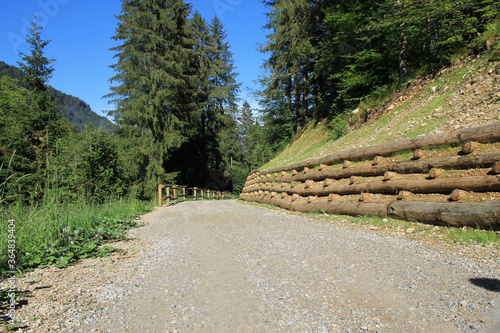 wooden log crib wall on alpine road, palificata viva ingegneria naturalistica