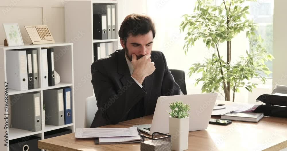Thoughtful businessman working on laptop at office Thoughtful businessman working on laptop at office