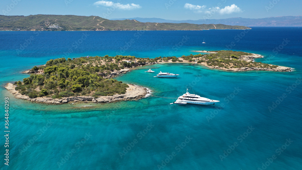 Obraz premium Aerial drone photo of Chinitsa bay a popular anchorage crystal clear turquoise sea bay for yachts and sail boats next to Porto Heli, Saronic gulf, Greece