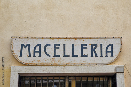 Close-up of a rusty metal shop sign with the Italian writing: 