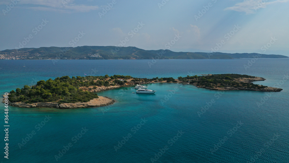 Fototapeta premium Aerial drone photo of Hinitsa bay a popular anchorage crystal clear turquoise sea bay for yachts and sail boats next to Porto Heli, Saronic gulf, Greece