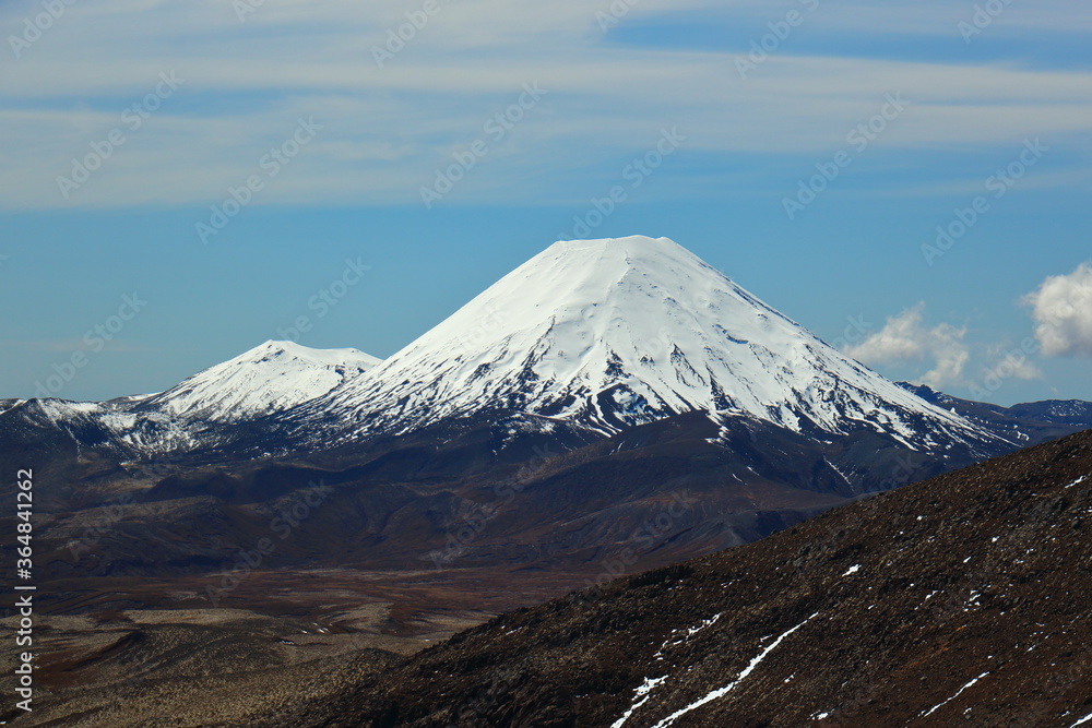 Mt Ngauruhoe and Mt Tongariro as seen across a valley from Whakapapa ski field on Mt Ruapehu, New Zealand, in spring