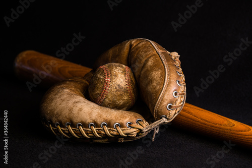 Photography Old baseball, bat and glove on black.
